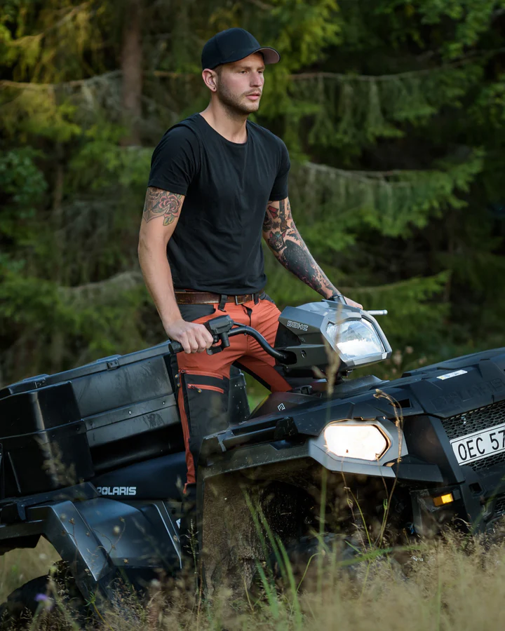 Herr trägt orangene Jagdhose Vännäs auf Quad